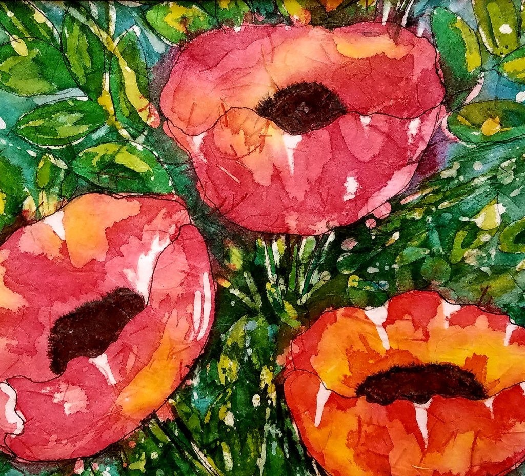 Batik watercolor painting of three bright red and orange poppies with dark centers, surrounded by lush green leaves and stems, creating a vibrant and lively floral scene.